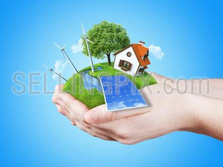 Hands holding clear green meadow with sun battery block, wind mill turbines and countryside house. Concept for ecology, alternative energy, freshness, freedom. Green fields collection.