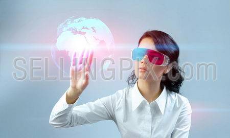 Fascinating brunette wearing 3d anaglyph stereo glasses. Operating futuristic 3d interface. Touching three-dimensional globe. One of a series.